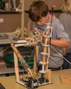 Boy building marble rollercoaster