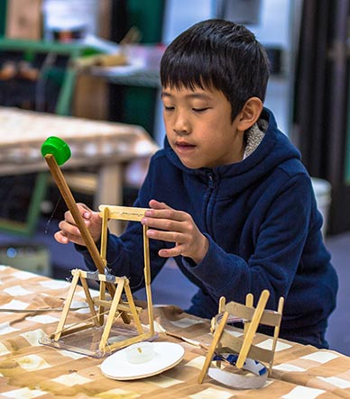 A boy makes a catapult to learn about the physics principle of stored energy.