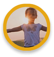 Child with arms outstretched to side, with sun behind