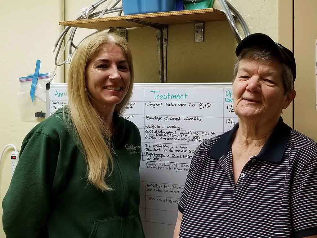 Two women stand in front of whiteboard