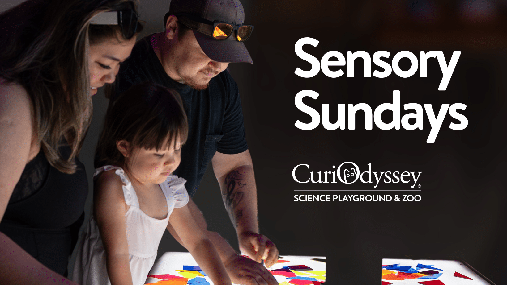 A family gathered around the light table at CuriOdyssey with a heading that says