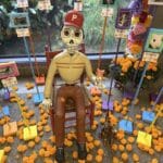 Sculpture of Pedro linares seated at the center of CuriOdyssey's animal ofrenda to celebrate Dia de los Muertos