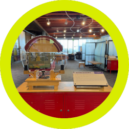A circular-framed photo of a museum exhibit featuring an interactive display with magnets. Visitors can engage with magnetic objects, exploring how they attract and repel each other (4)